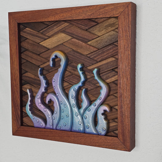 Handcrafted wooden wall decor featuring multiple 3D iridescent tentacles reaching upward. The tentacles have a glittery lilac-to-teal gradient and textured suction cups, mounted on a dark brown basket-weave wood inlay within a square wooden frame.