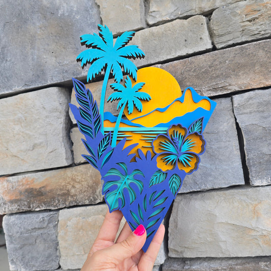 A multi-layered, laser-cut wooden art piece with an un-framed geometric border. It features bright teal palm trees, a large yellow sun setting behind a layered wood backdrop, and dark blue tropical leaves paired with a prominent blue and yellow hibiscus flower at the base.
