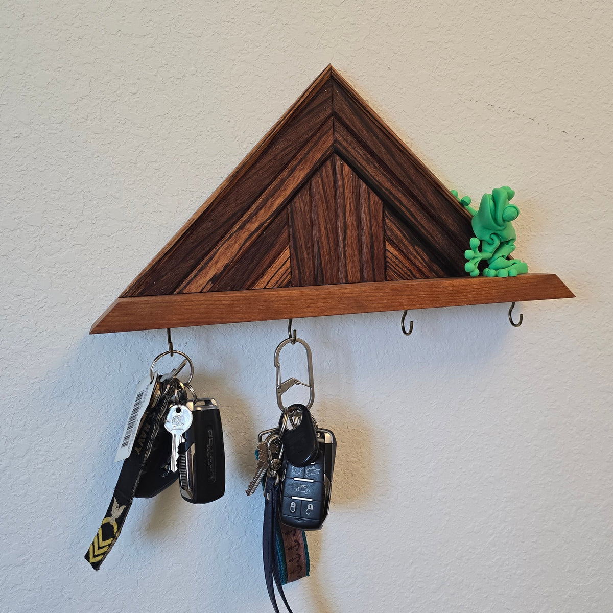 Triangular mosaic key holder with a little 3d printed frog on the edge.