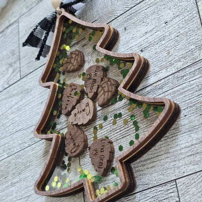 Christmas Tree wooden outline with clear acrylic top. inside is pinecone shapes engraved with names and chunky green and gold glitter