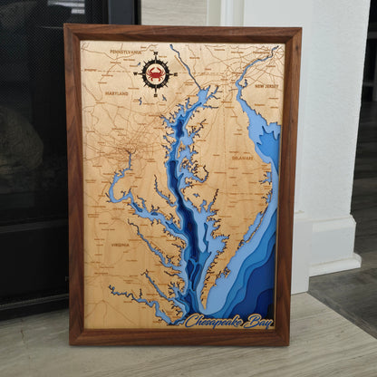 3D bathymetric map of the Chesapeake Bay from Virginia to Pennsylvania with wooden frame and 'Chesapeake Bay' label. Compass rose contains a Red Crab