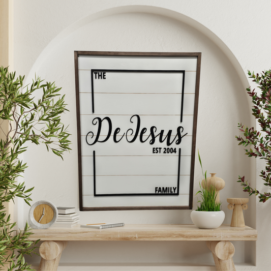 Framed family name sign on a wall with decorative elements