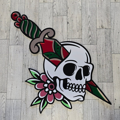 Decorative skull design with flowers and knife through skull on a wooden floor.