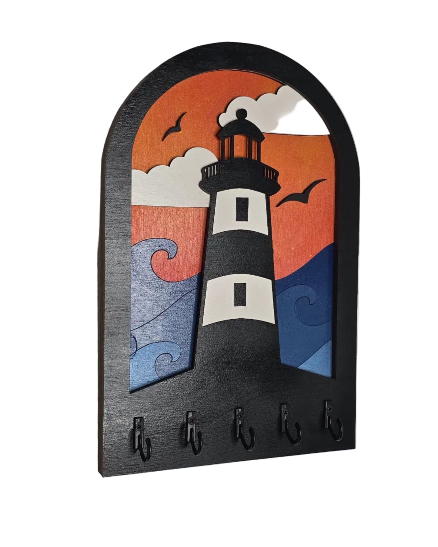 Decorative key holder with a design of a lighthouse in front of waves and clouds with an gradient orange sky