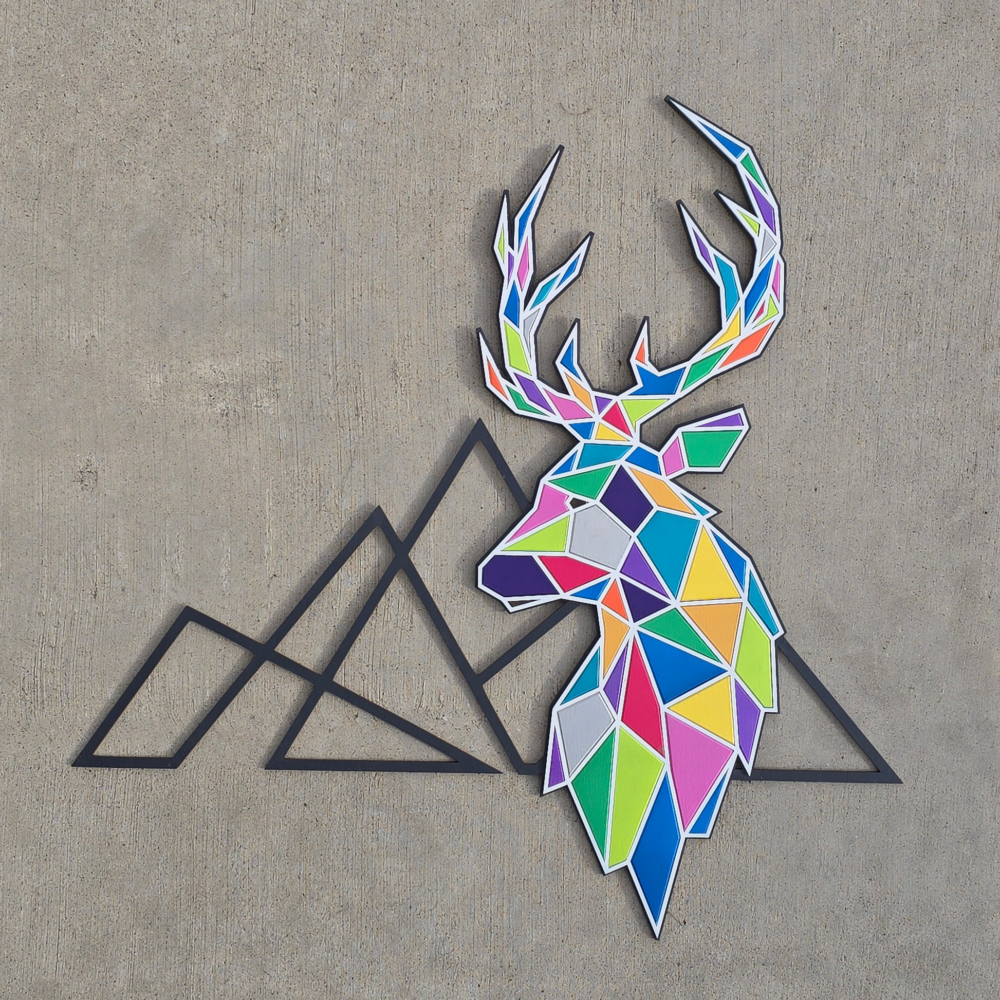Geometric deer head and mountain outlines on concreate surface