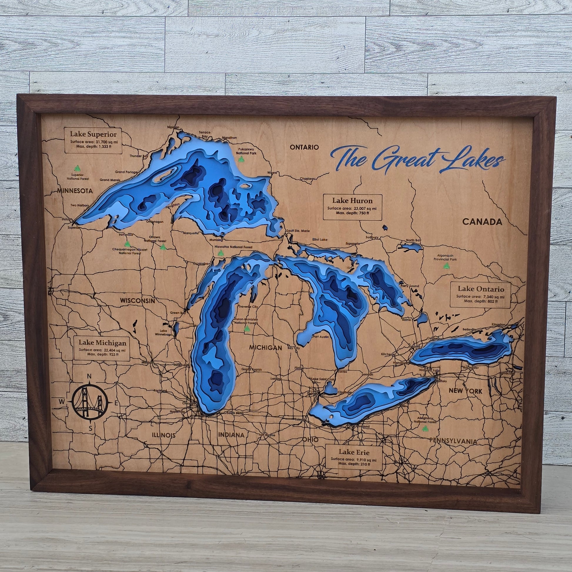 Map of The Great Lakes with wooden frame and blue water features on a light gray surface
