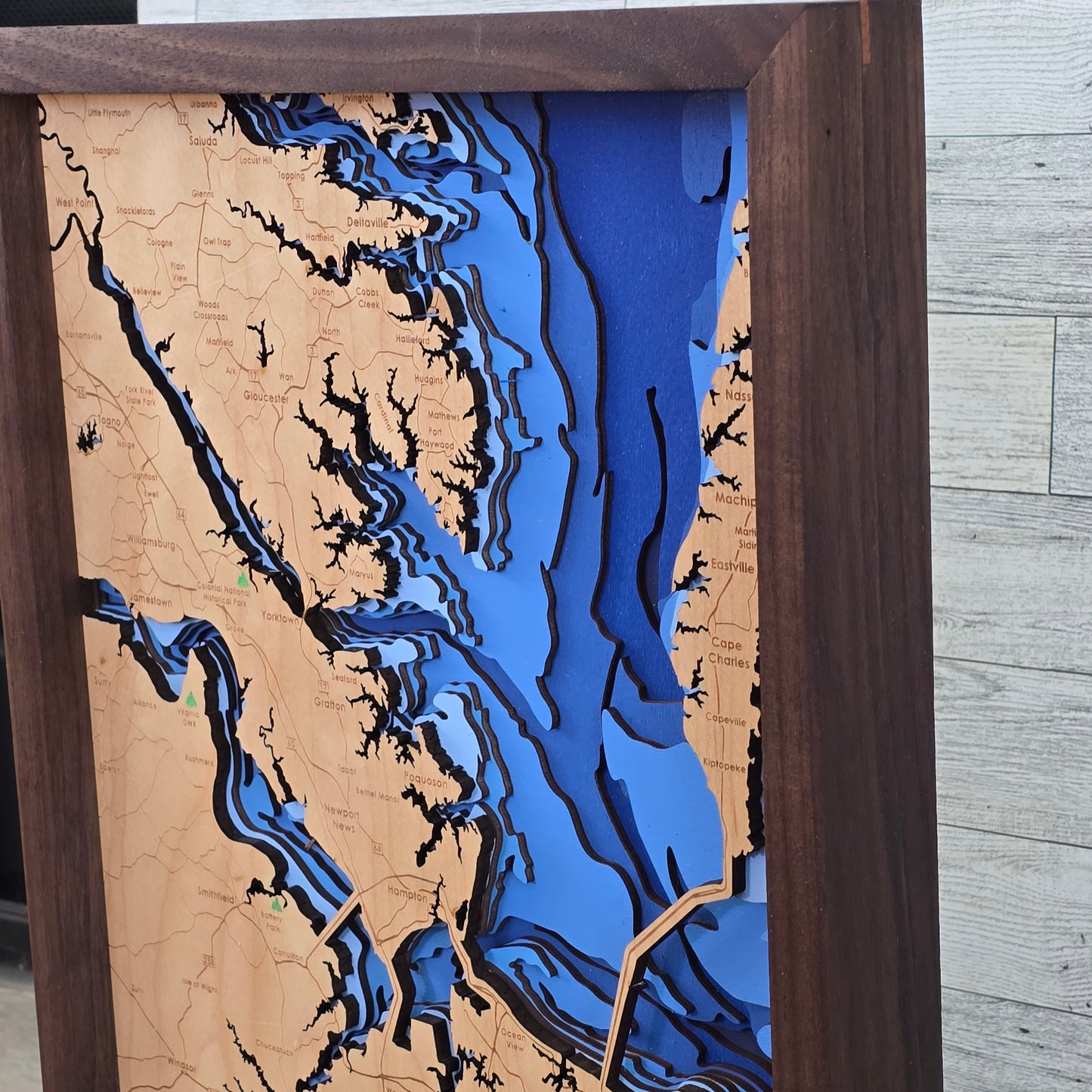 Wooden map with bathymetric details of a coastal area Hampton Roads Virginia, framed in brown.