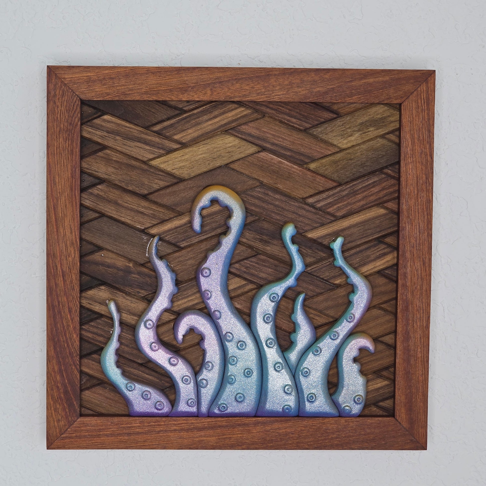 3D iridescent octopus tentacle wall art with a shimmering purple and blue finish on a dark woven wood background with a mahogany-toned frame.