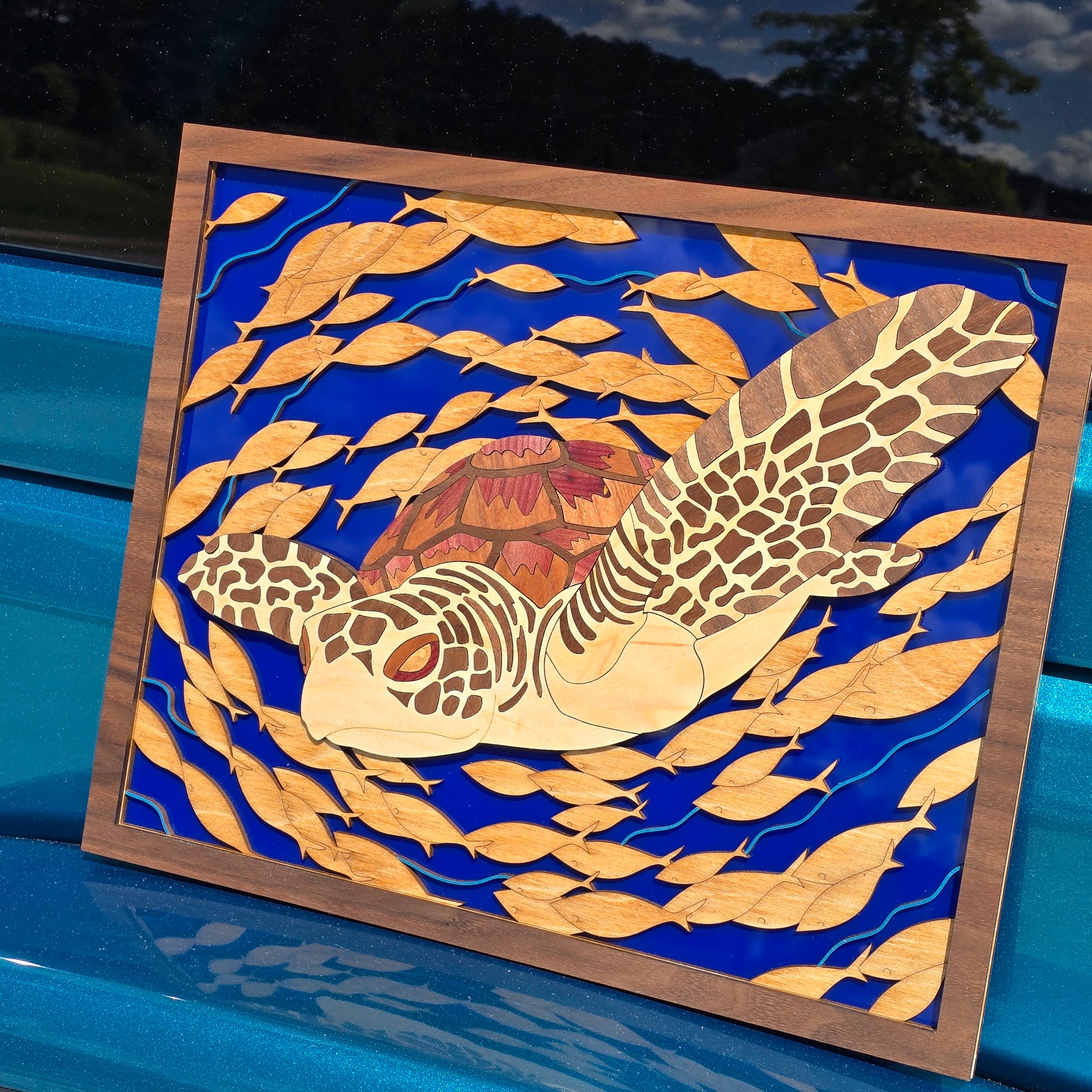 Decorative wall art with a turtle design on a blue background