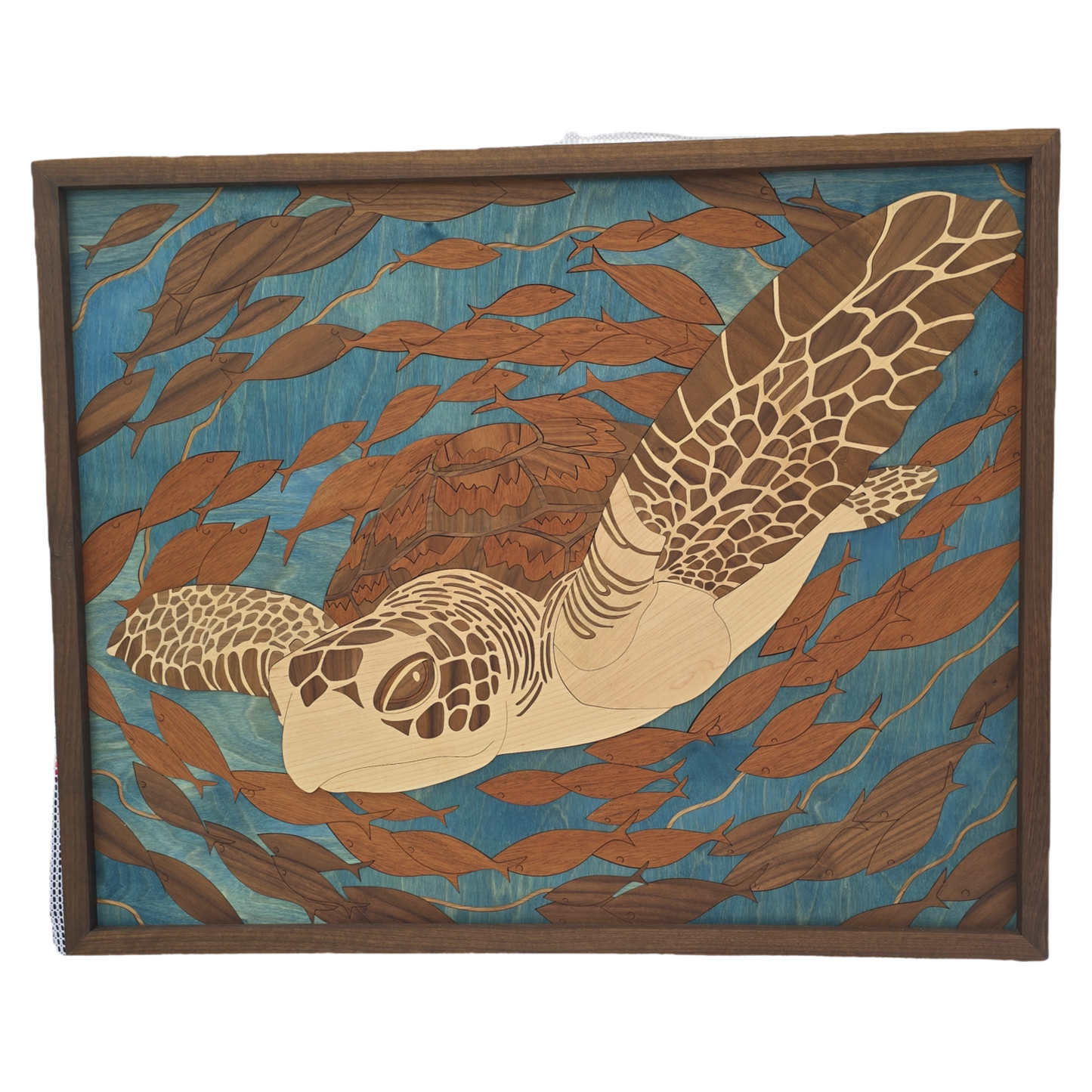 Wooden wall art with a turtle design in a natural setting