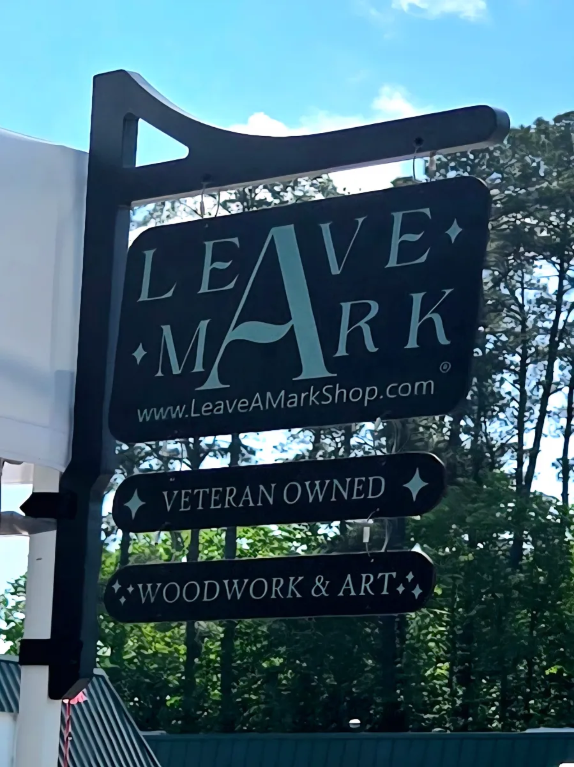 Outdoor sign for Leave A Mark with branding and product information.