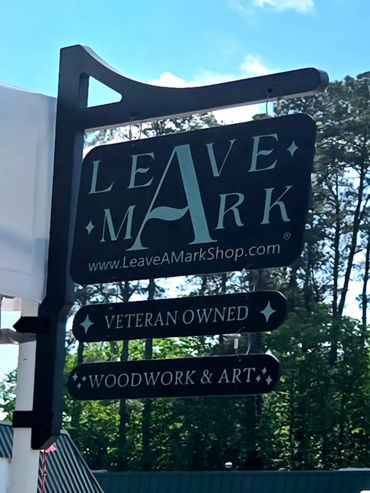 Outdoor sign for Leave A Mark with branding and product information.
