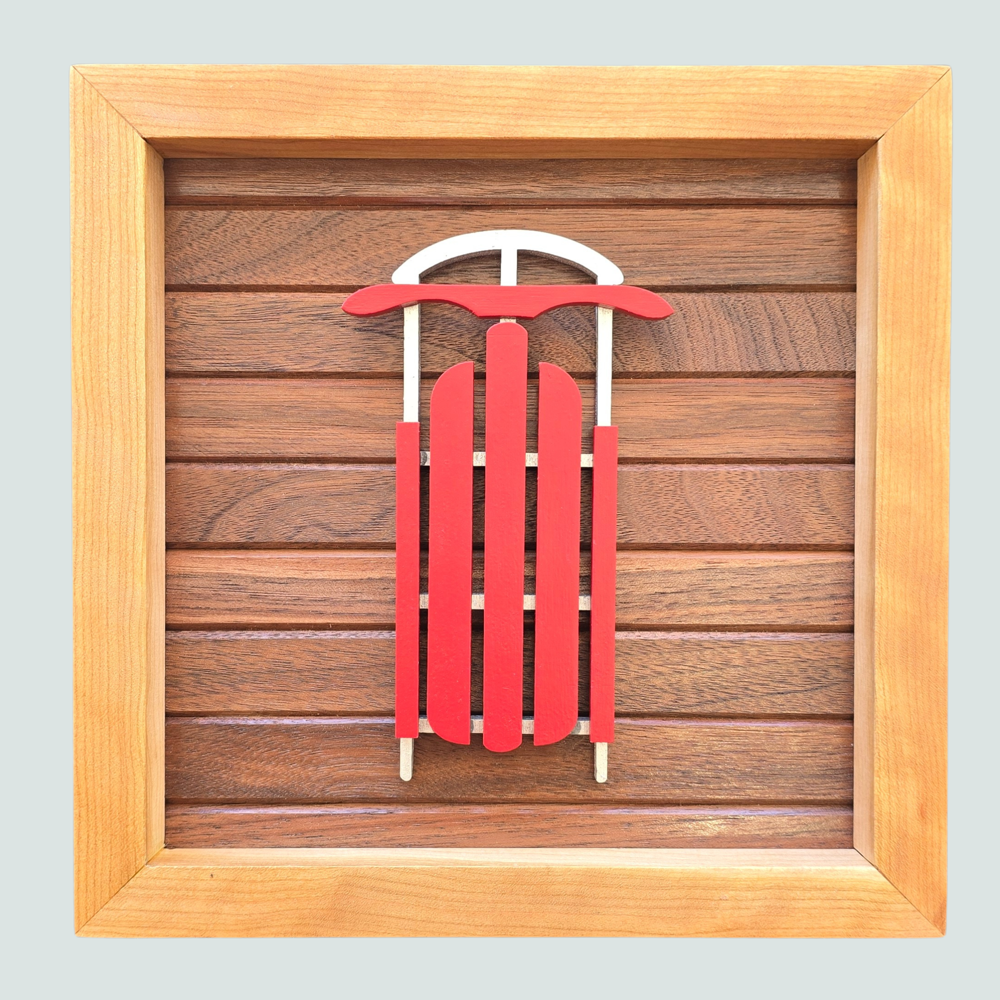 Red sled with white runners on a wooden background