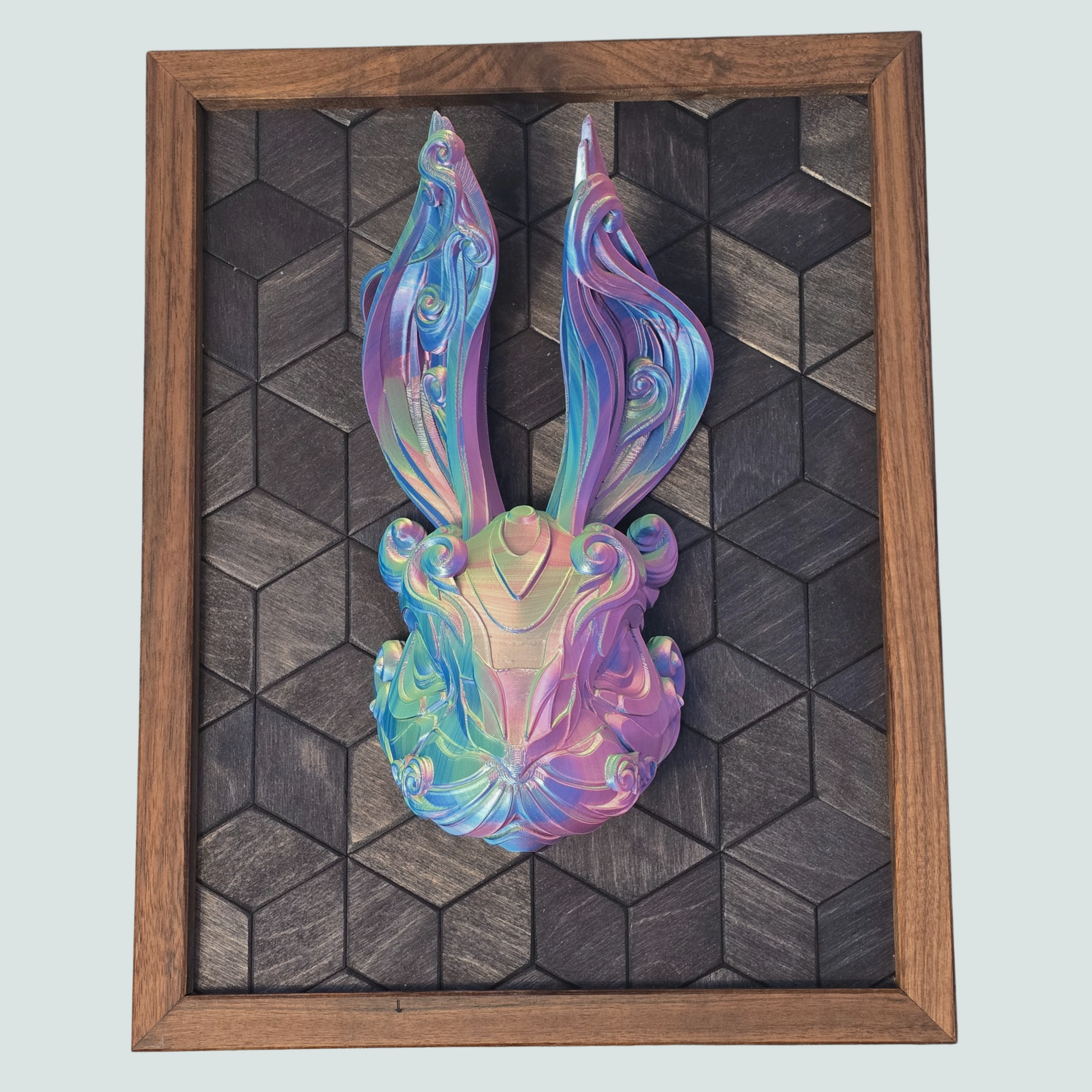 Colorful abstract 3D Printed sculpture of a rabbit head in a wooden frame on a geometric-patterned background