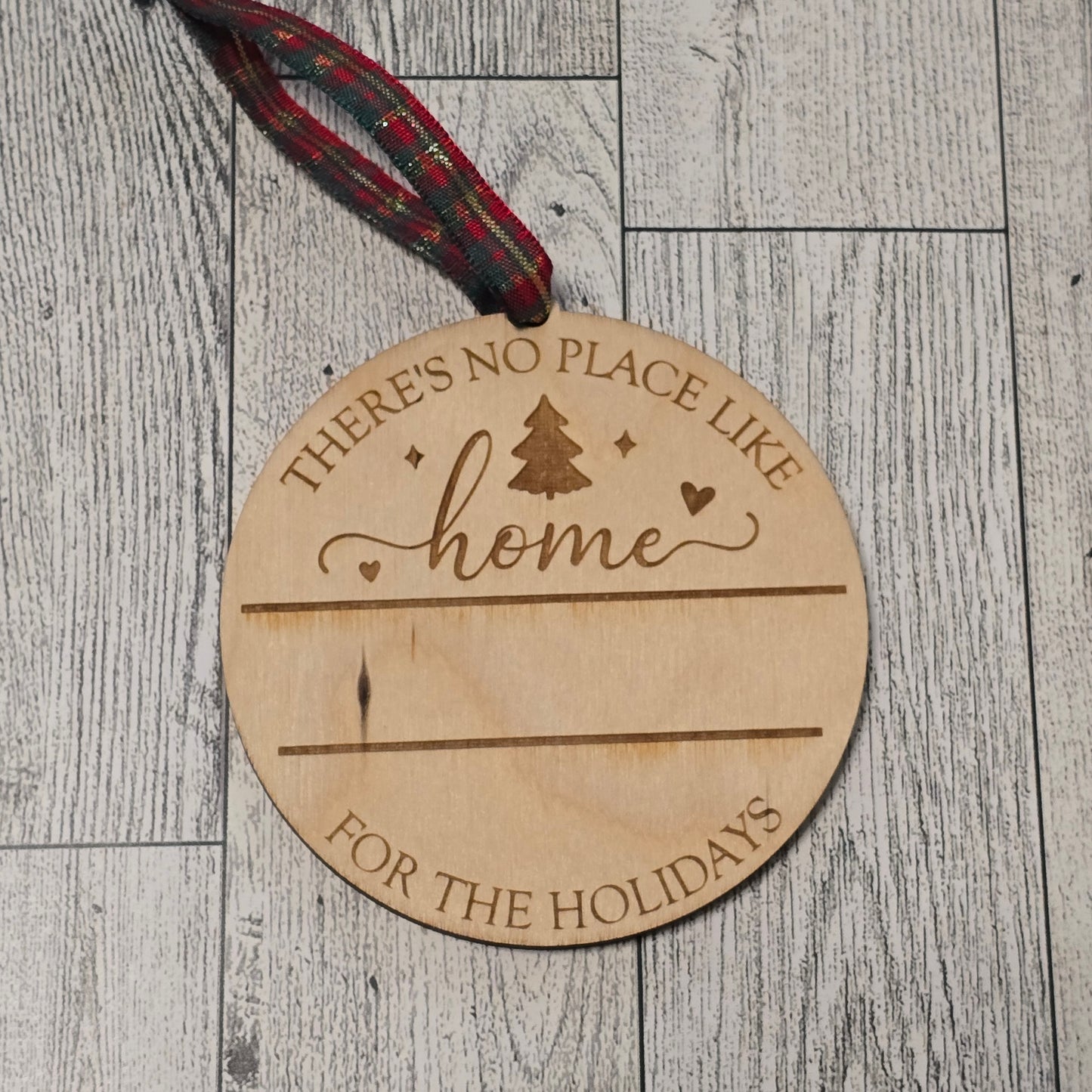 Wooden ornament with engraved text on a wooden surface