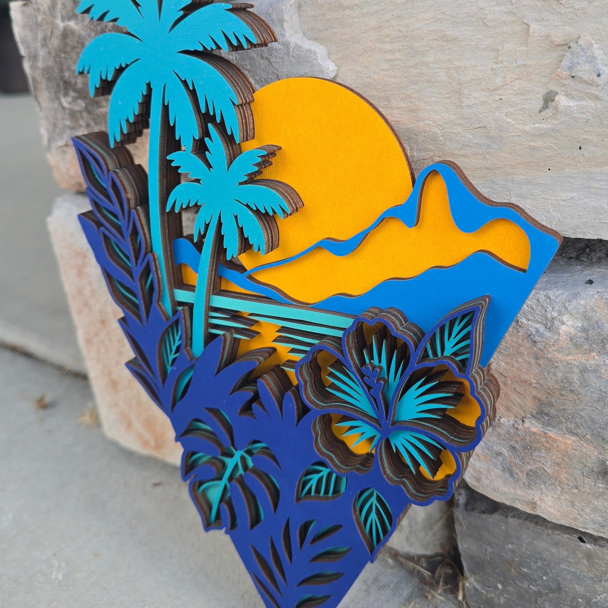 "Soundside Sunset" multi-layered tropical geometric wood art featuring a sunset silhouette, palm trees, and hibiscus details