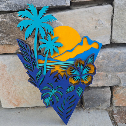 Layered geometric wood art featuring a yellow sunset, teal palm trees, and a tropical hibiscus flower on a textured gray background.