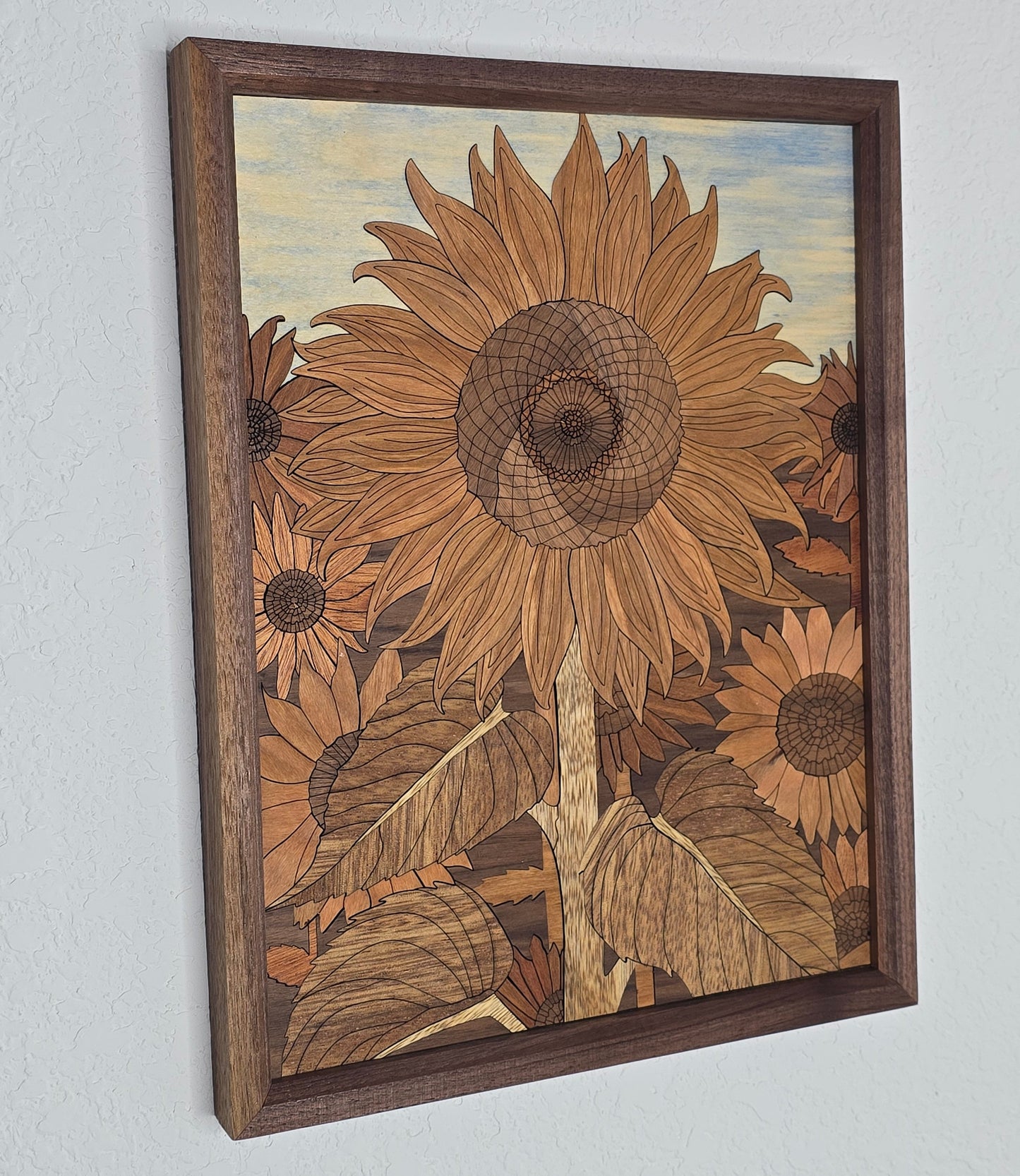 Wooden inlaid artwork of sunflowers on a light gray background