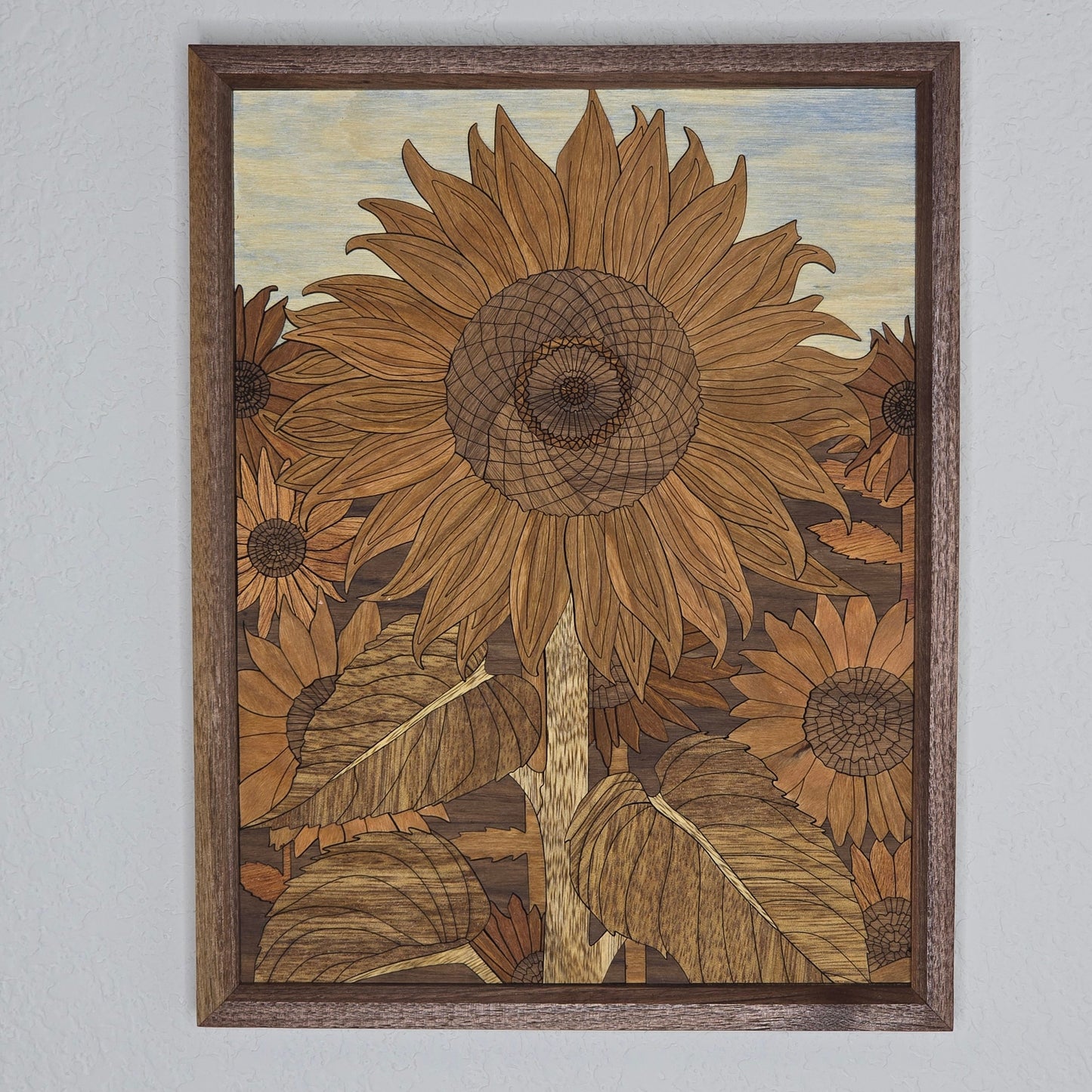 Framed artwork of sunflowers on a plain wall