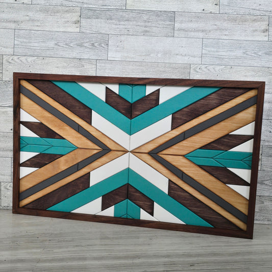 Geometric wooden wall art with a brown, teal, and beige pattern on a wooden floor.