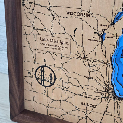 Wooden map of Lake Michigan with engraved details on a wooden frame, upclose shot of the compass rose with the mackinac bridge