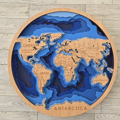 3D layered world map on a wooden frame with blue oceans and brown landmasses.