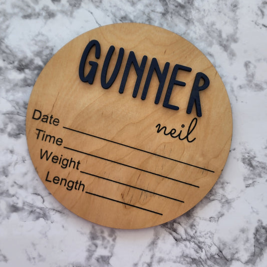 Wooden round plaque with engraved text on a marble surface