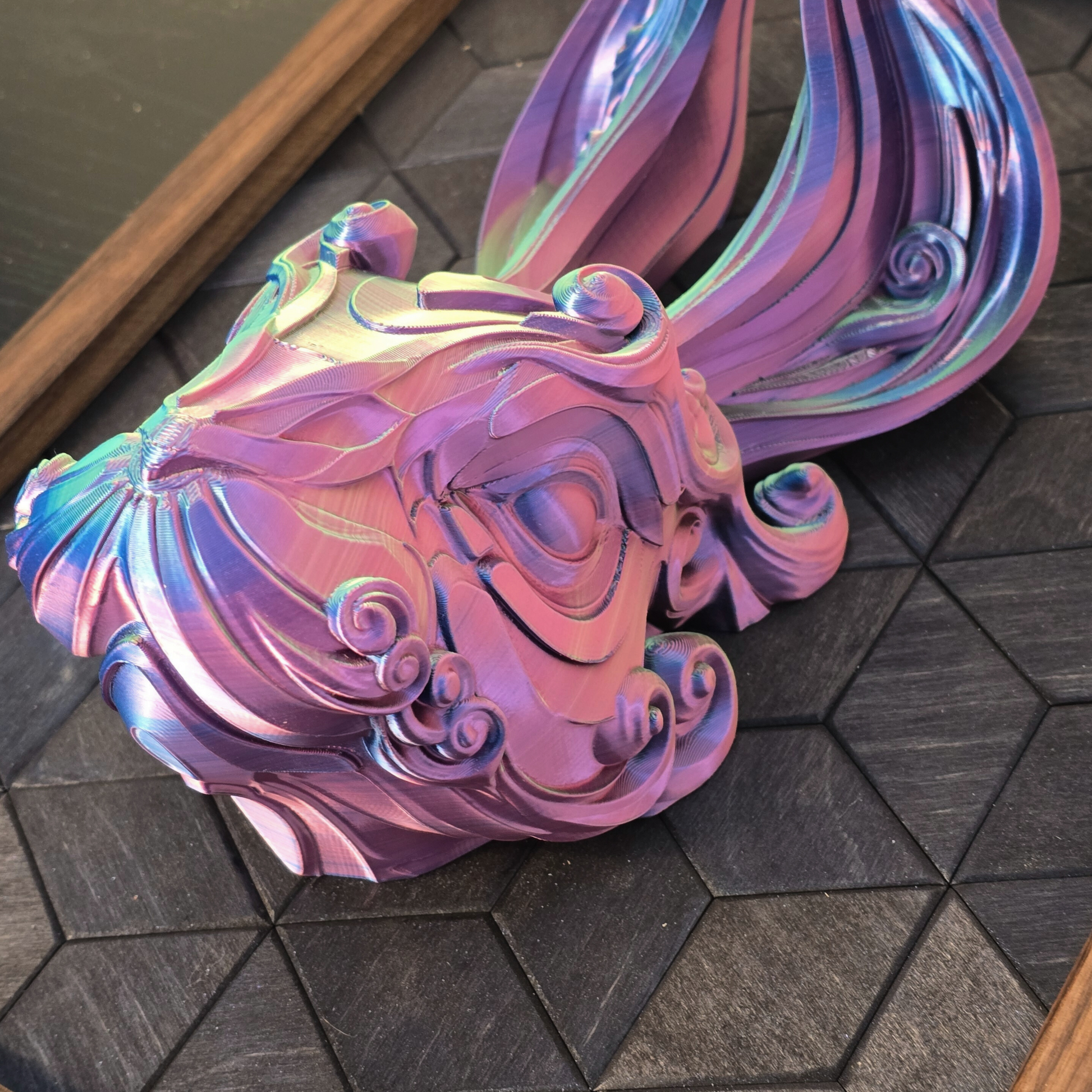 Colorful abstract 3D Printed sculpture of a rabbit head in a wooden frame on a geometric-patterned background