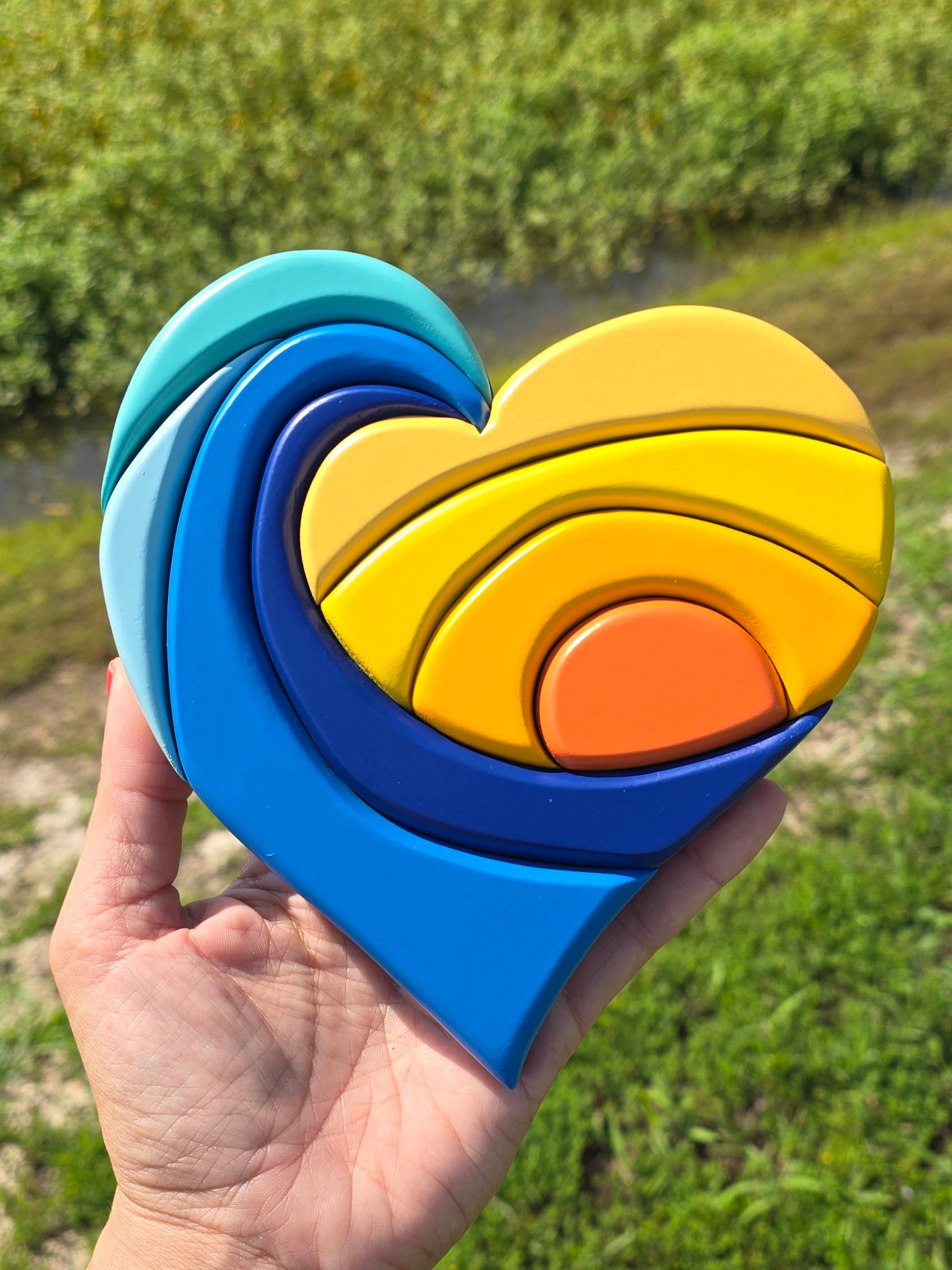 Clip of a heart shape that is carved into waves and a sunset with shades of blues and yellows. 