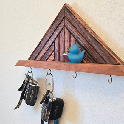 Wooden key holder with keys attached on a white wall.